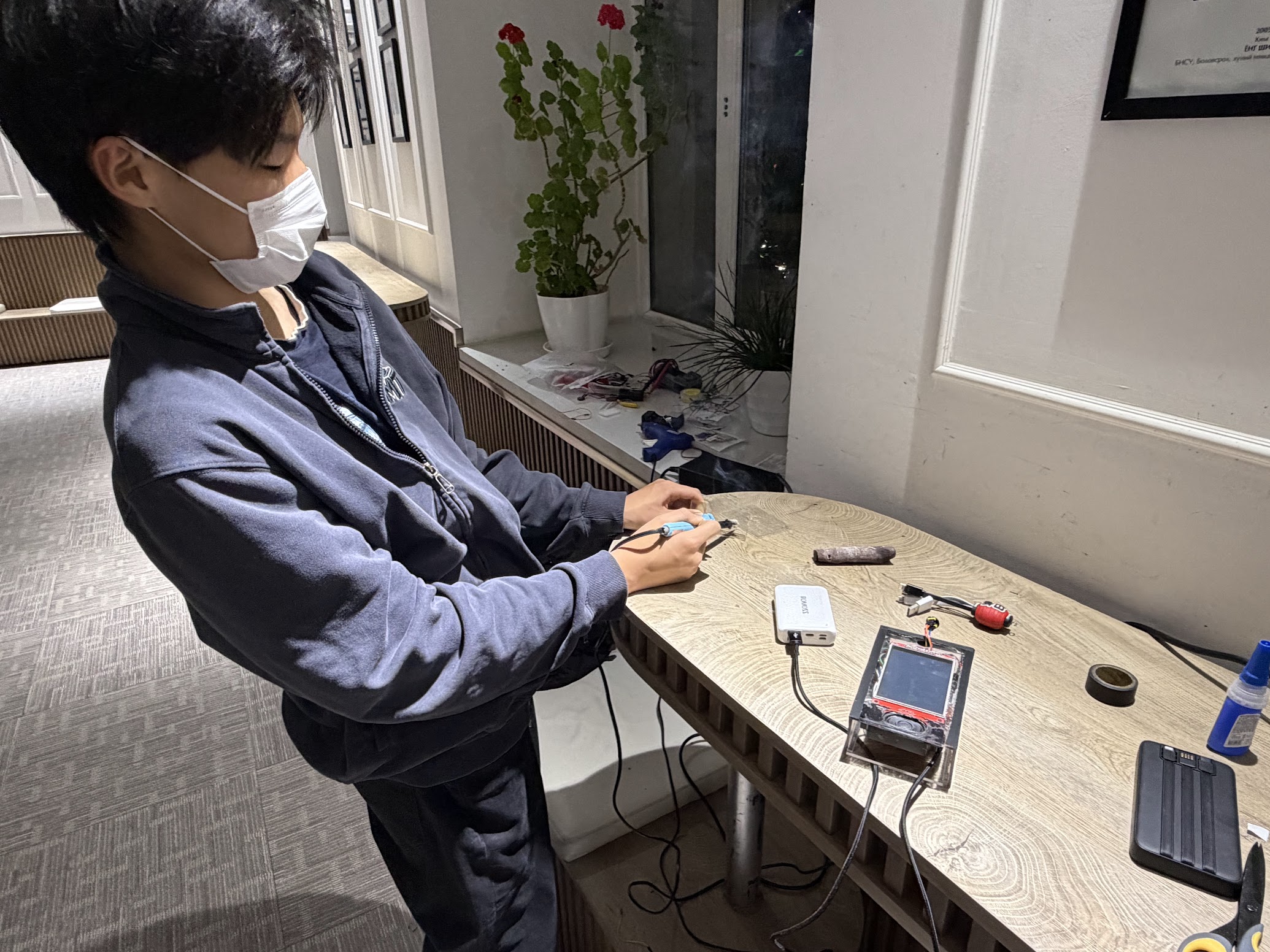 Itgel soldering components at a workbench